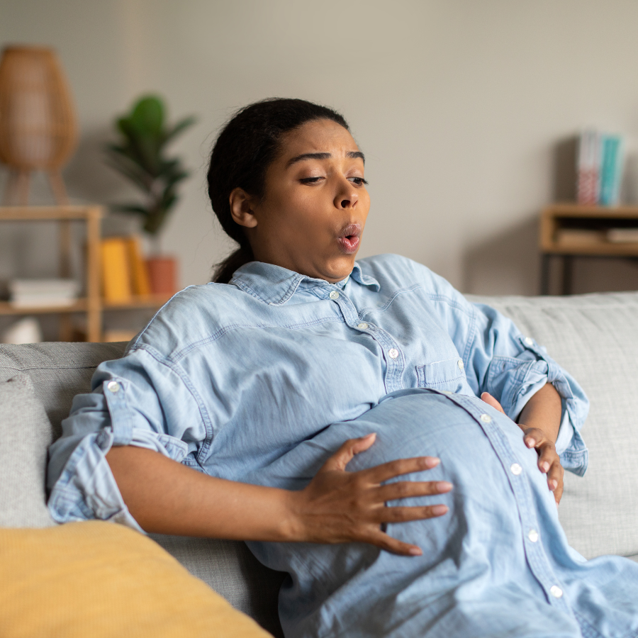 A pregnant woman exercising gently, incorporating breathing and relaxation techniques for well-being and stress relief