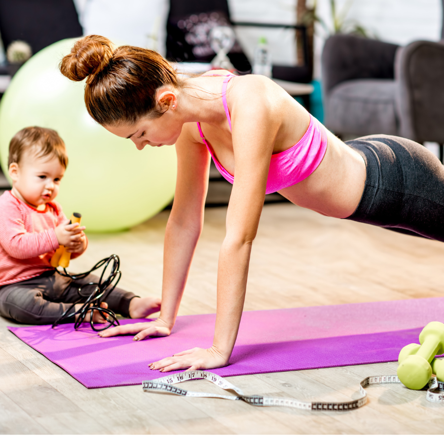 Mother doing postpartum exercise with the baby beside