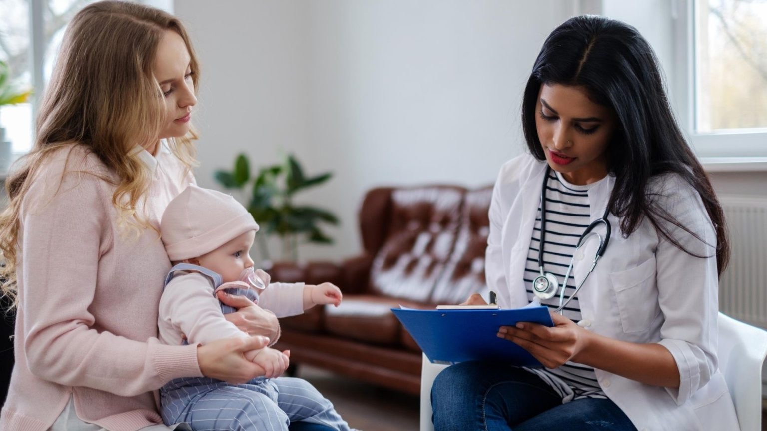 A new mom with a baby consulting a healthcare provider following self-care tips for new moms during postpartum recovery.