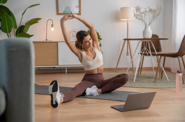 Mother practicing yoga at home using self-care tips for new moms to break the cycle of exhaustion.